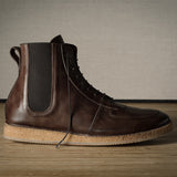 Brown leather boot with cork sole on a wooden floor