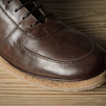 Brown leather shoe on a wooden surface