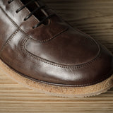 Brown leather shoe on a wooden surface