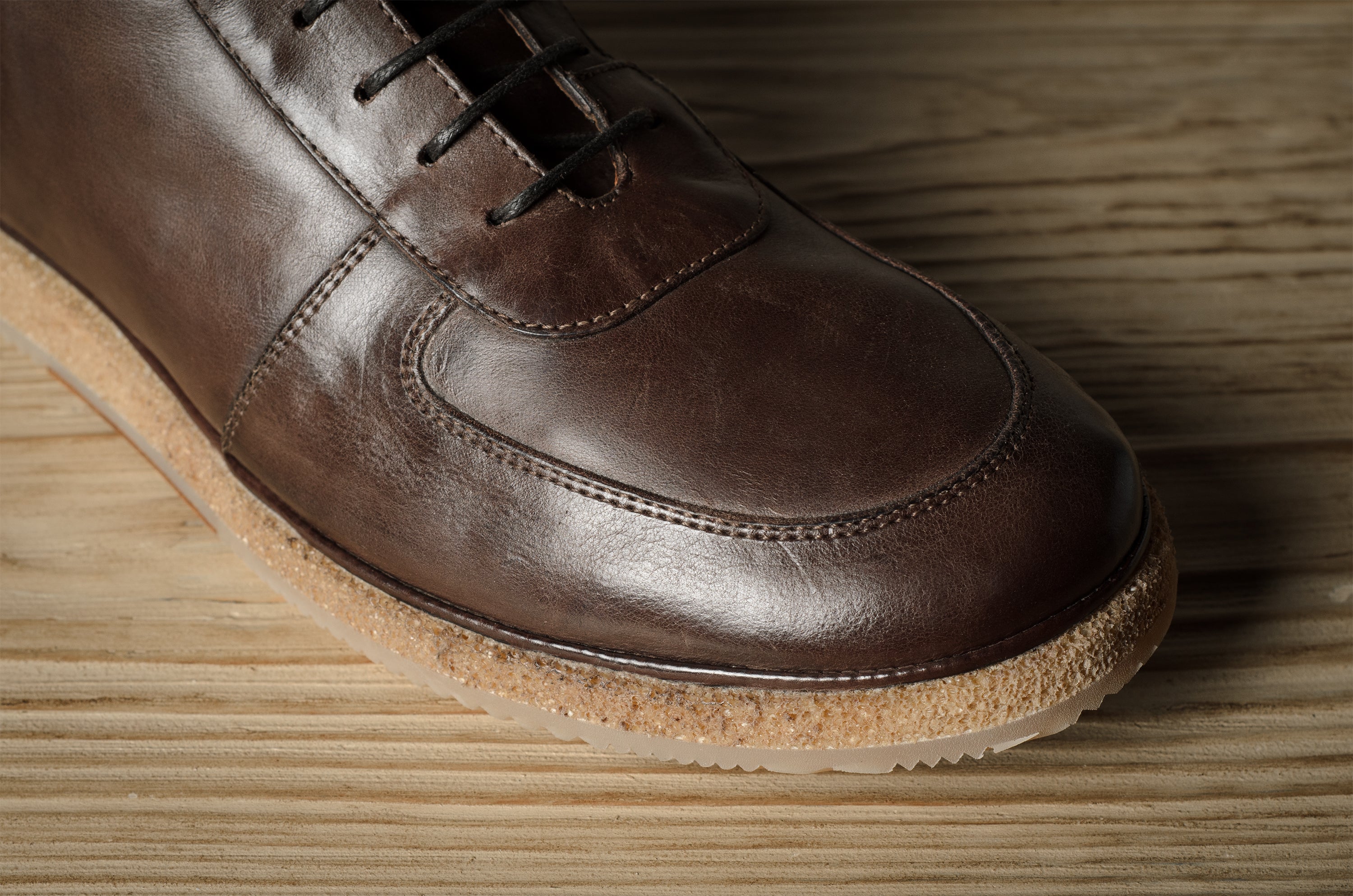 Brown leather shoe on a wooden surface