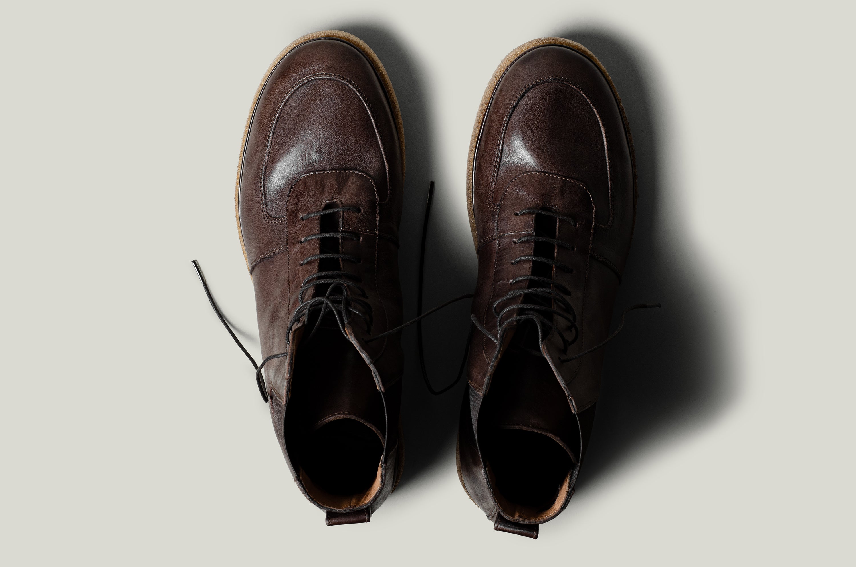 Pair of brown leather boots on a light gray background