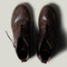 Pair of brown leather boots on a light gray background