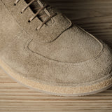 Brown suede shoe on a wooden surface