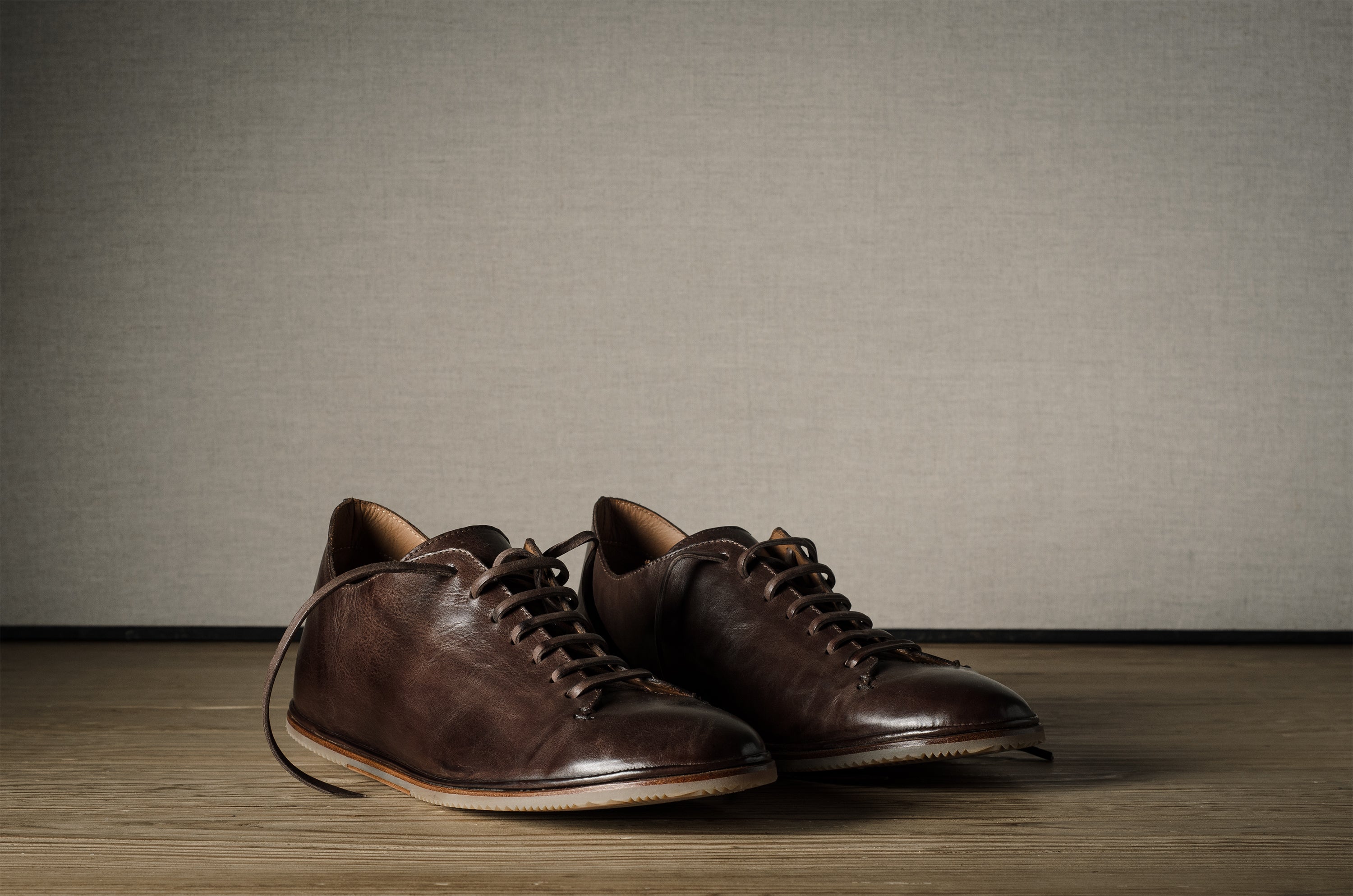 Pair of brown leather shoes on a wooden floor.