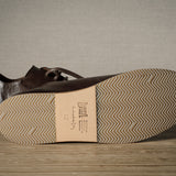 Pair of brown leather shoes on a wooden floor.