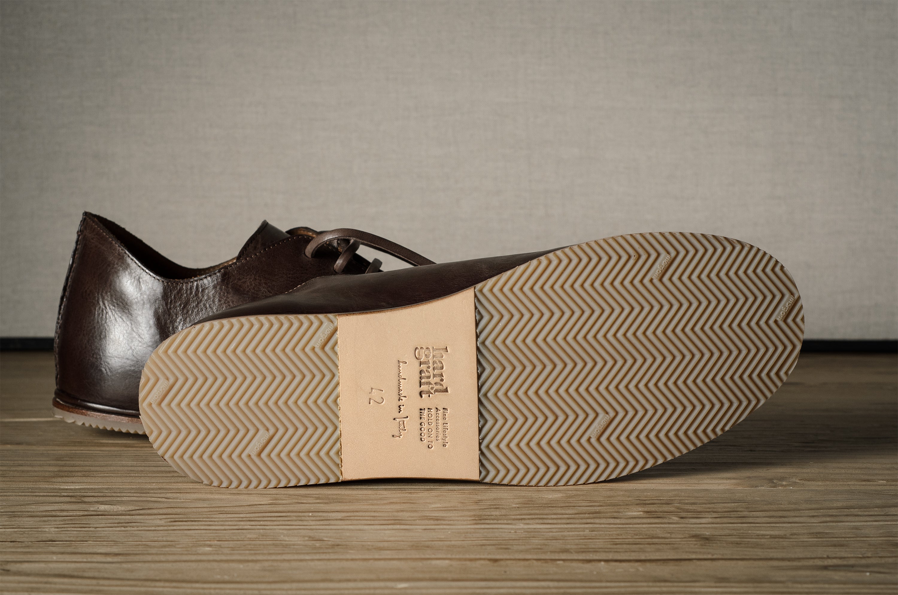 Pair of brown leather shoes on a wooden floor.