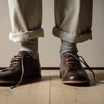 Pair of brown leather shoes on a wooden floor.
