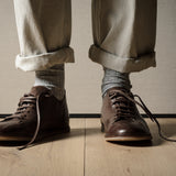 Pair of brown leather shoes on a wooden floor.