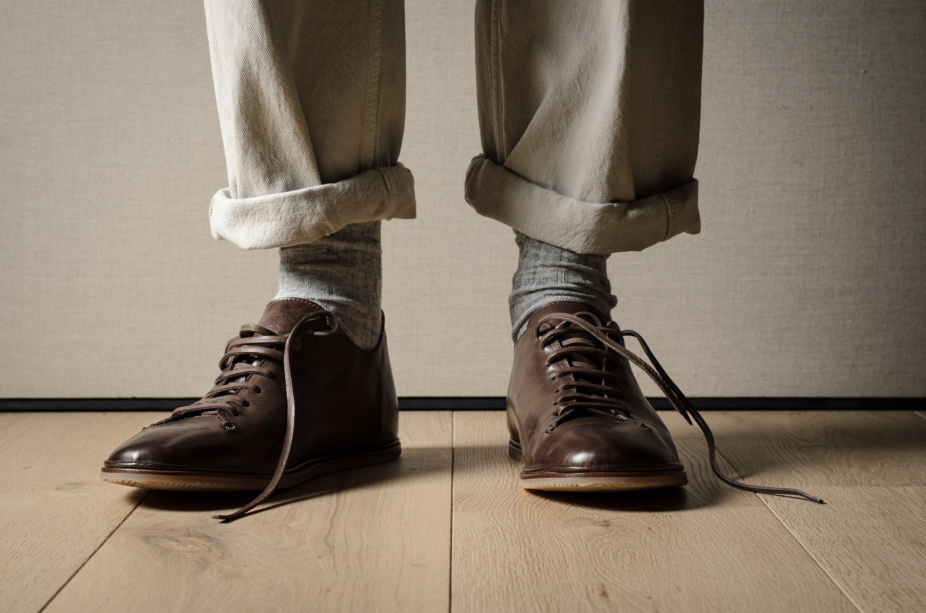 Pair of brown leather shoes on a wooden floor.