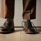 Pair of brown leather shoes on a wooden floor.
