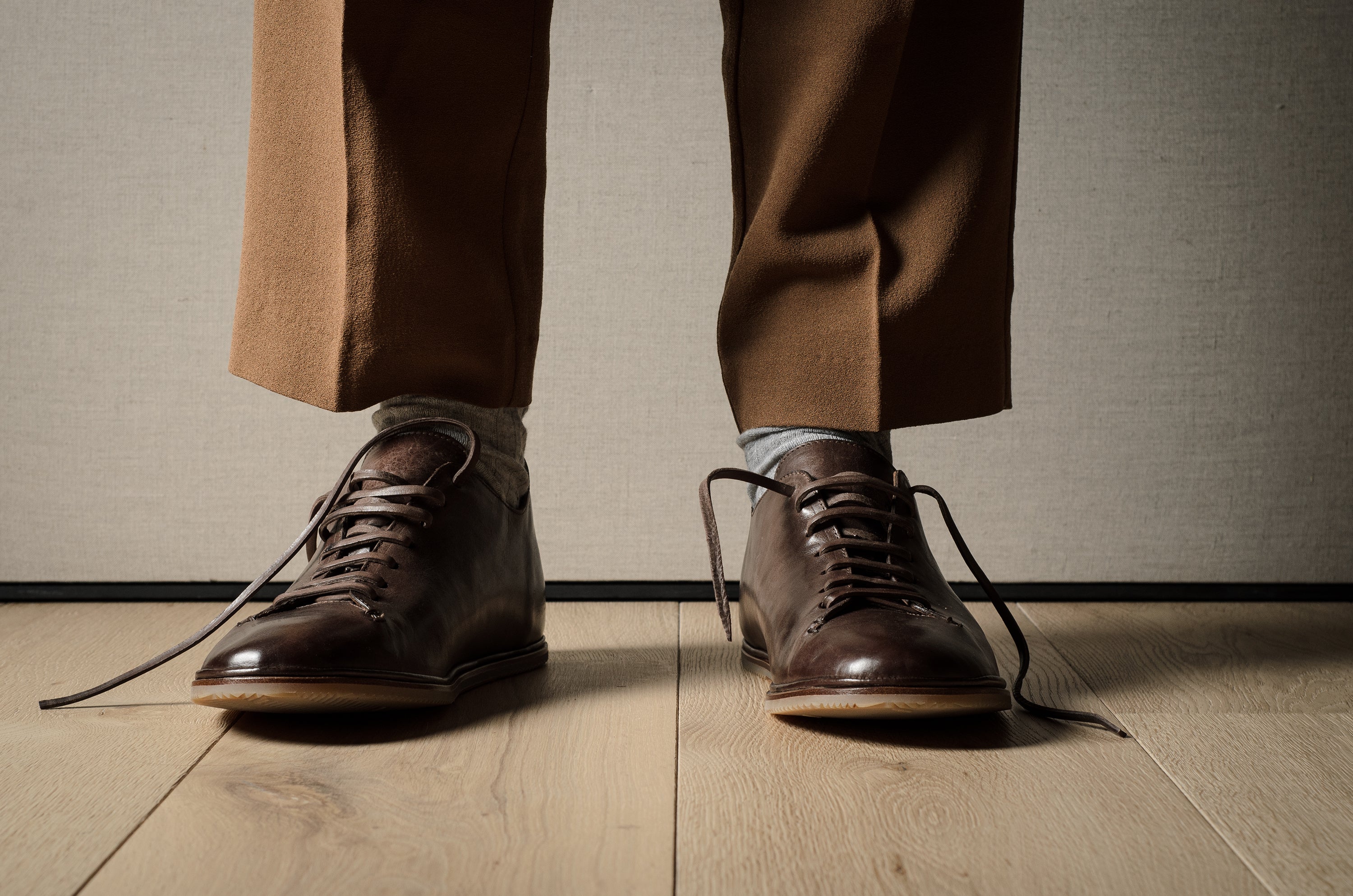 Pair of brown leather shoes on a wooden floor.
