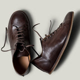 Pair of brown leather shoes on a light gray background