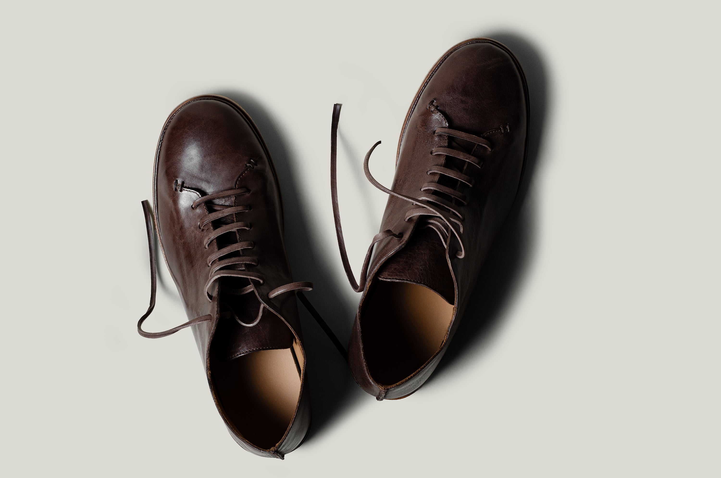 Pair of brown leather shoes on a light gray background