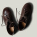 Pair of brown leather shoes on a light gray background