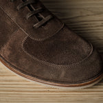 Brown suede shoe on a wooden surface