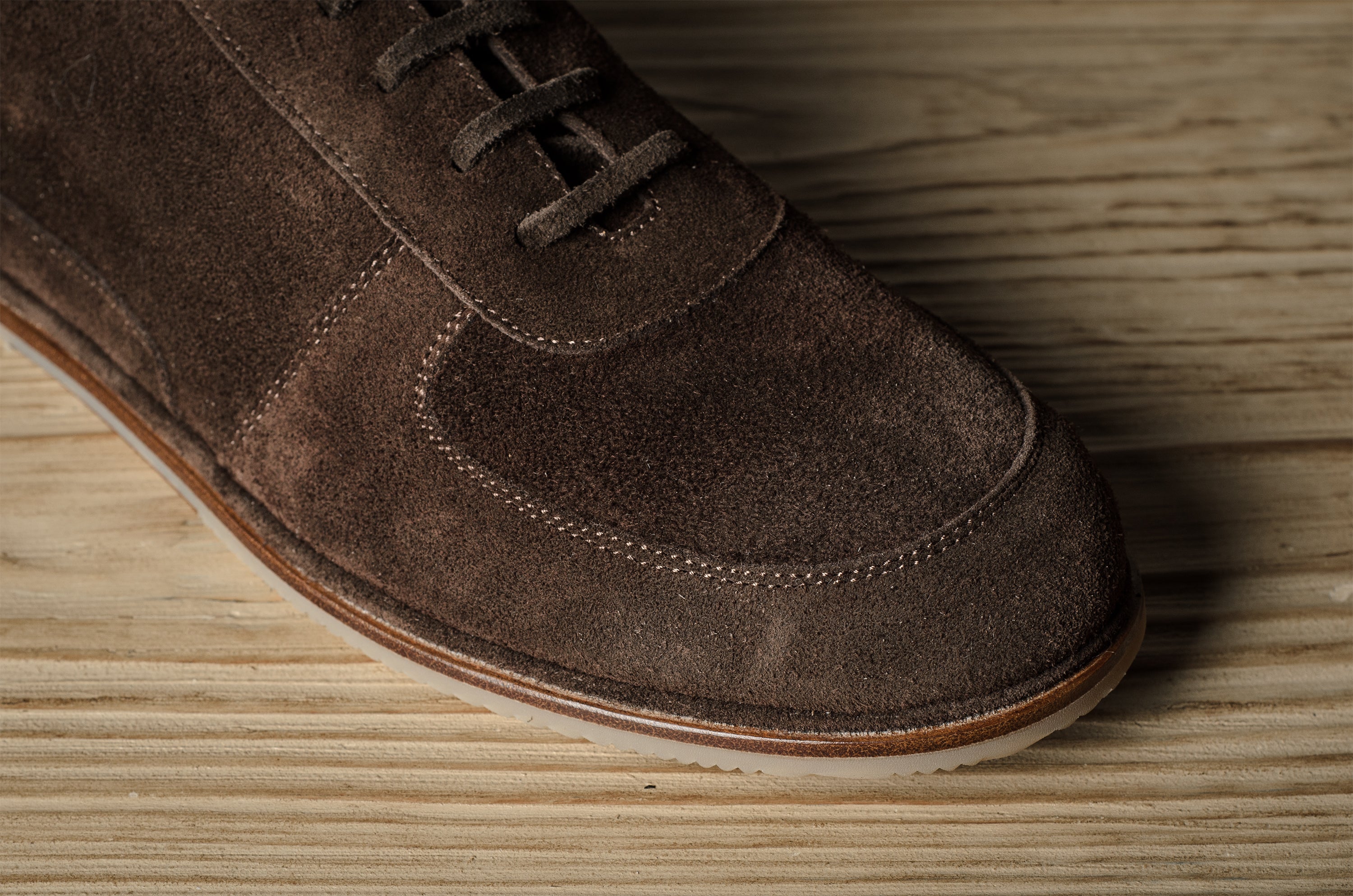 Brown suede shoe on a wooden surface