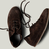 Pair of brown suede shoes on a light gray background