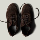 Pair of brown suede shoes on a light gray background