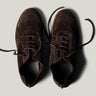 Pair of brown suede shoes on a light gray background