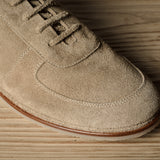 Beige suede shoe on a wooden surface
