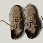 Pair of brown suede shoes on a light gray background