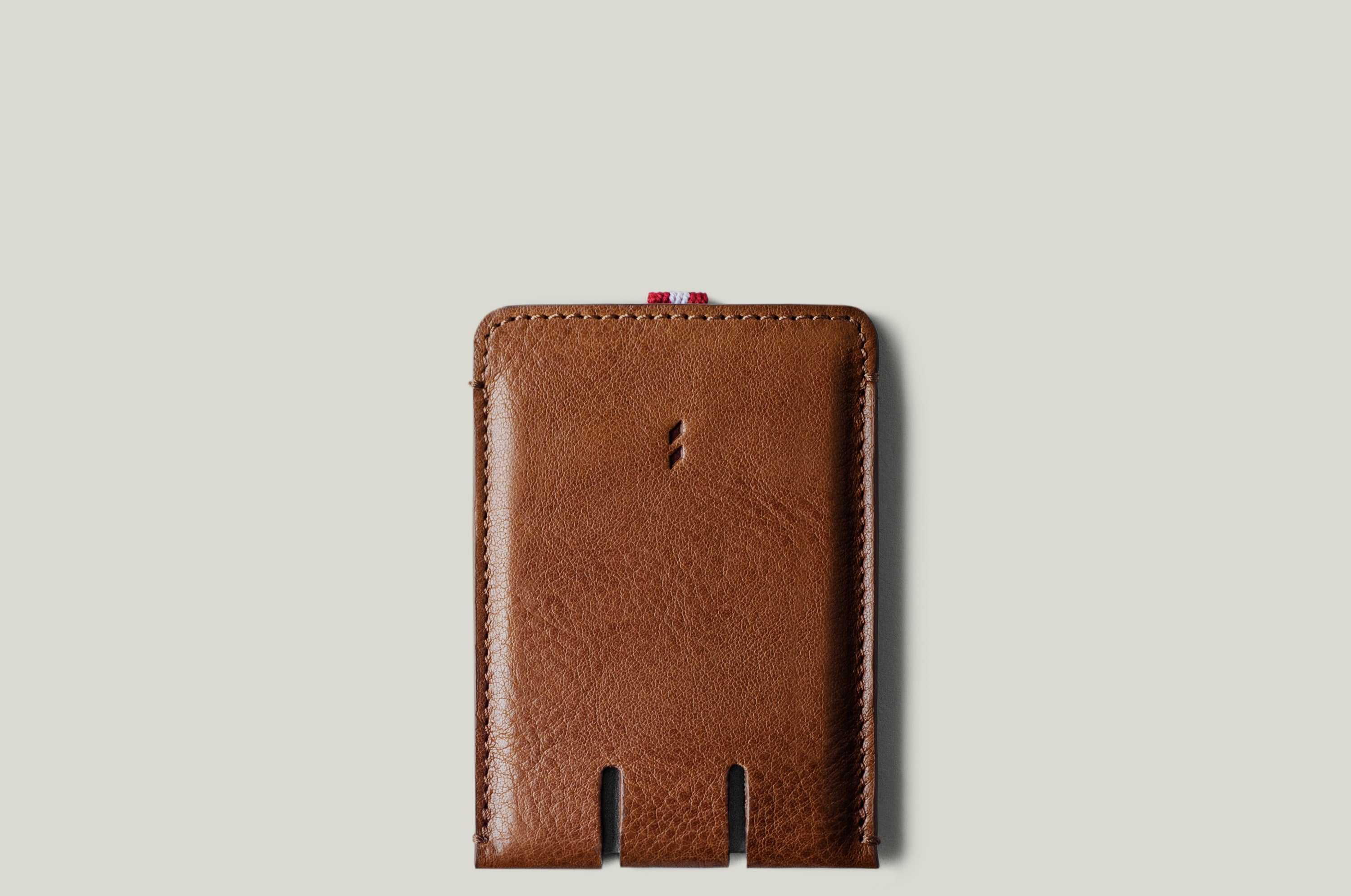 Brown leather card case on a light gray background