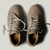 Pair of brown suede sneakers on a light gray background