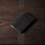 Black leather passport case on a wooden surface