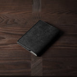 Black leather passport case on a wooden surface