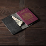 Black leather passport case on a wooden surface