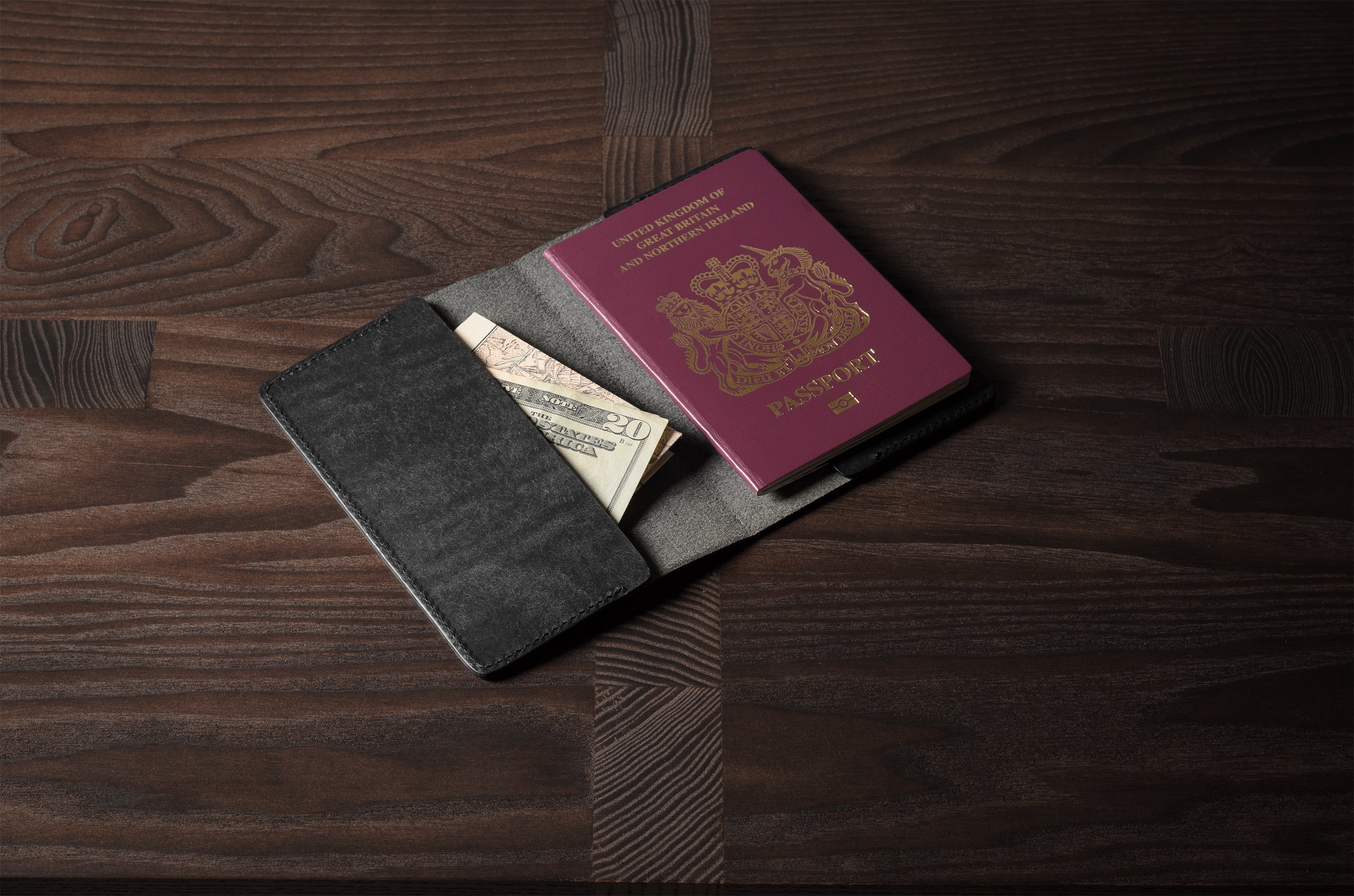 Black leather passport case on a wooden surface
