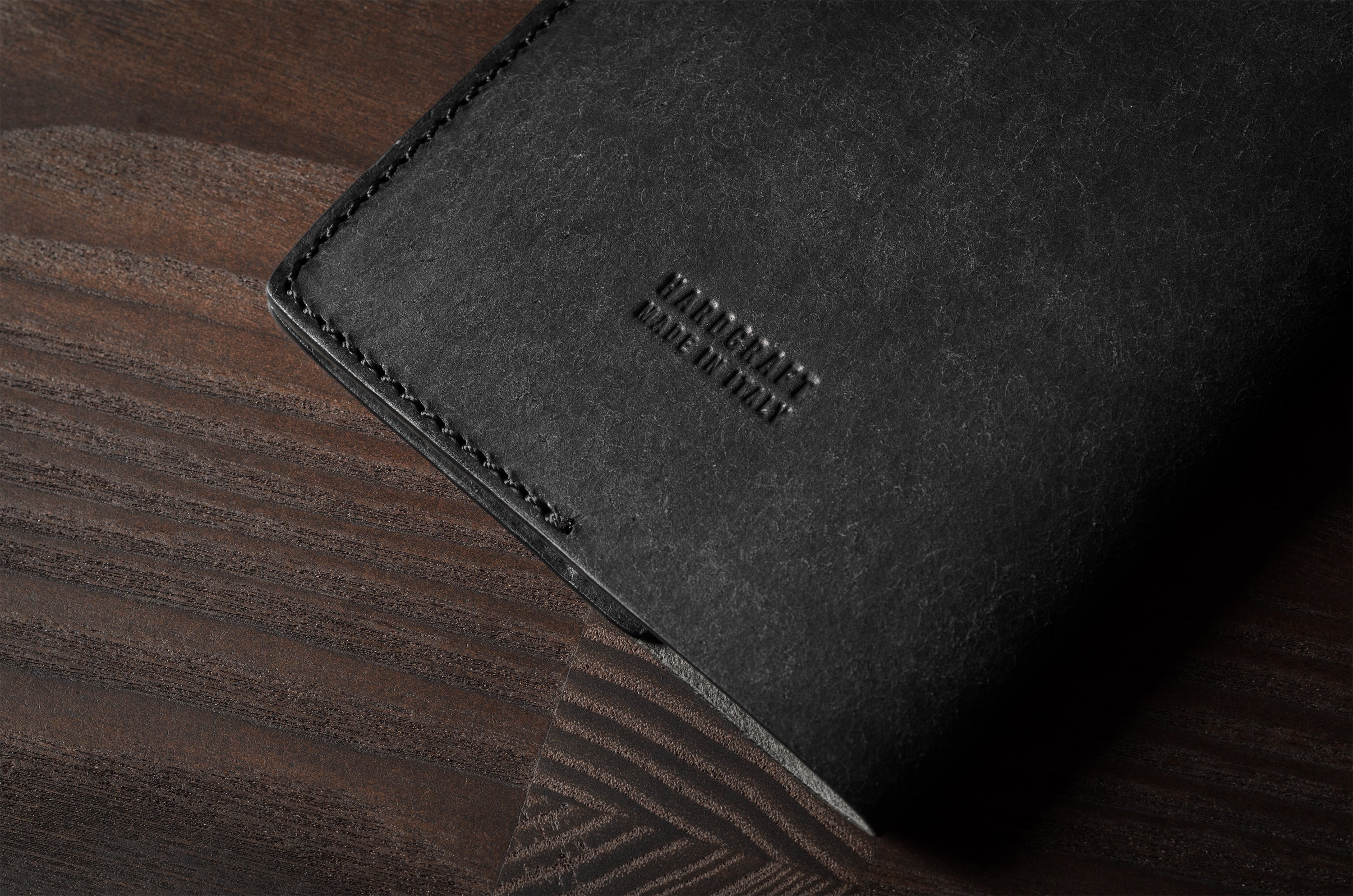 Black leather passport case on a wooden surface