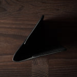 Black leather passport case on a wooden surface