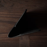 Black leather passport case on a wooden surface