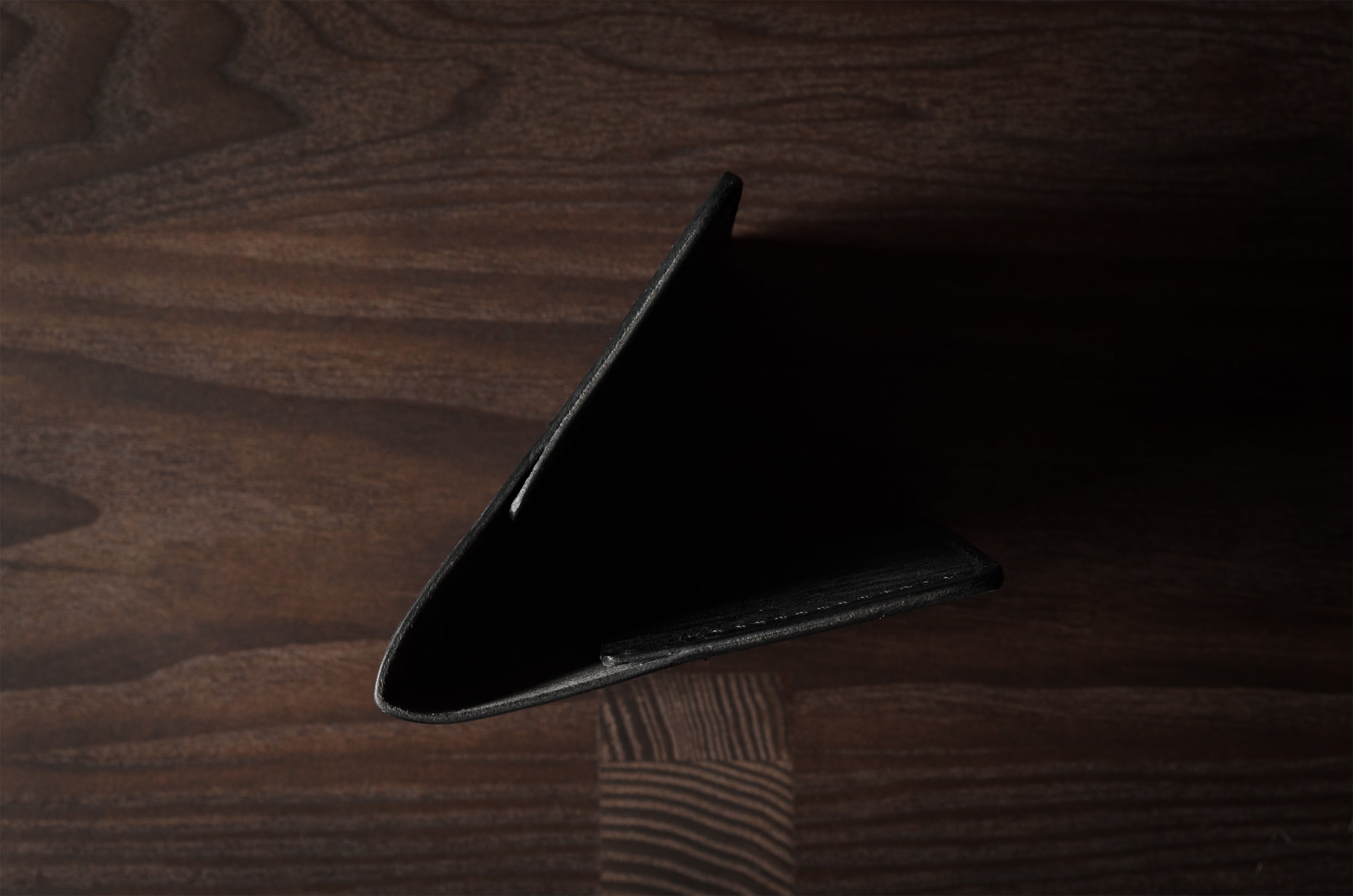 Black leather passport case on a wooden surface