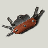 Multi-key pouch made of brown leather on a light gray background