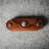 Multi-key pouch made of brown leather on a gray background