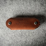 Multi-key pouch made of brown leather on a gray background