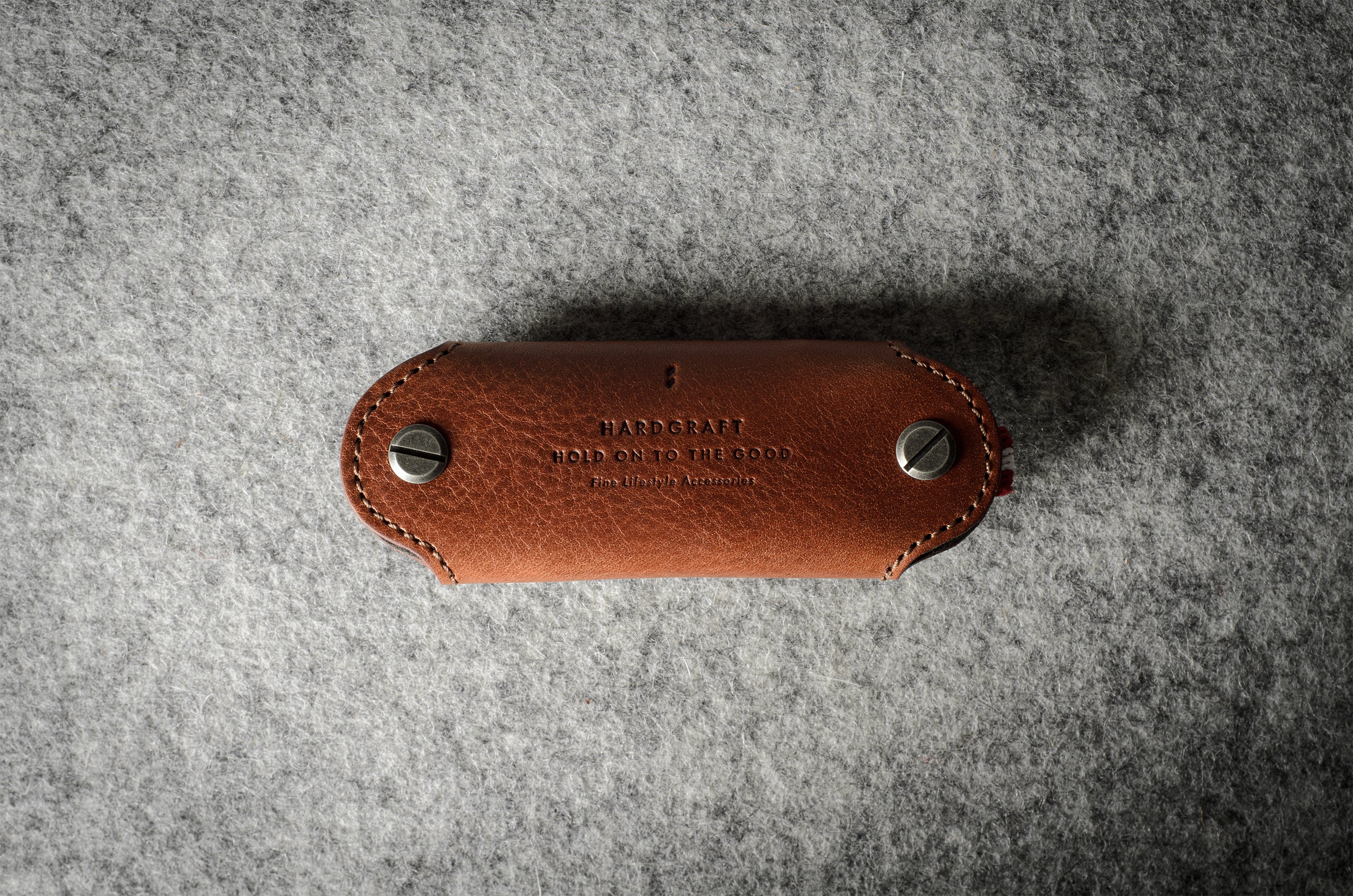 Multi-key pouch made of brown leather on a gray background