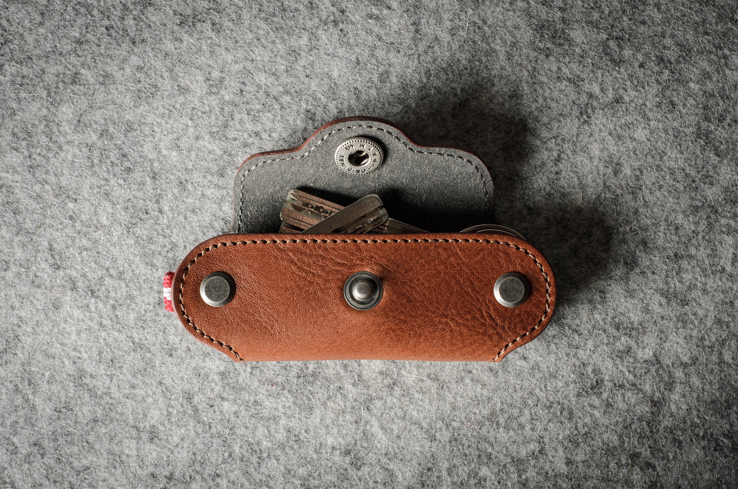 Multi-key pouch made of brown leather on a gray background