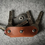 Multi-key pouch made of brown leather on a gray background