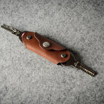Multi-key pouch made of brown leather on a gray background