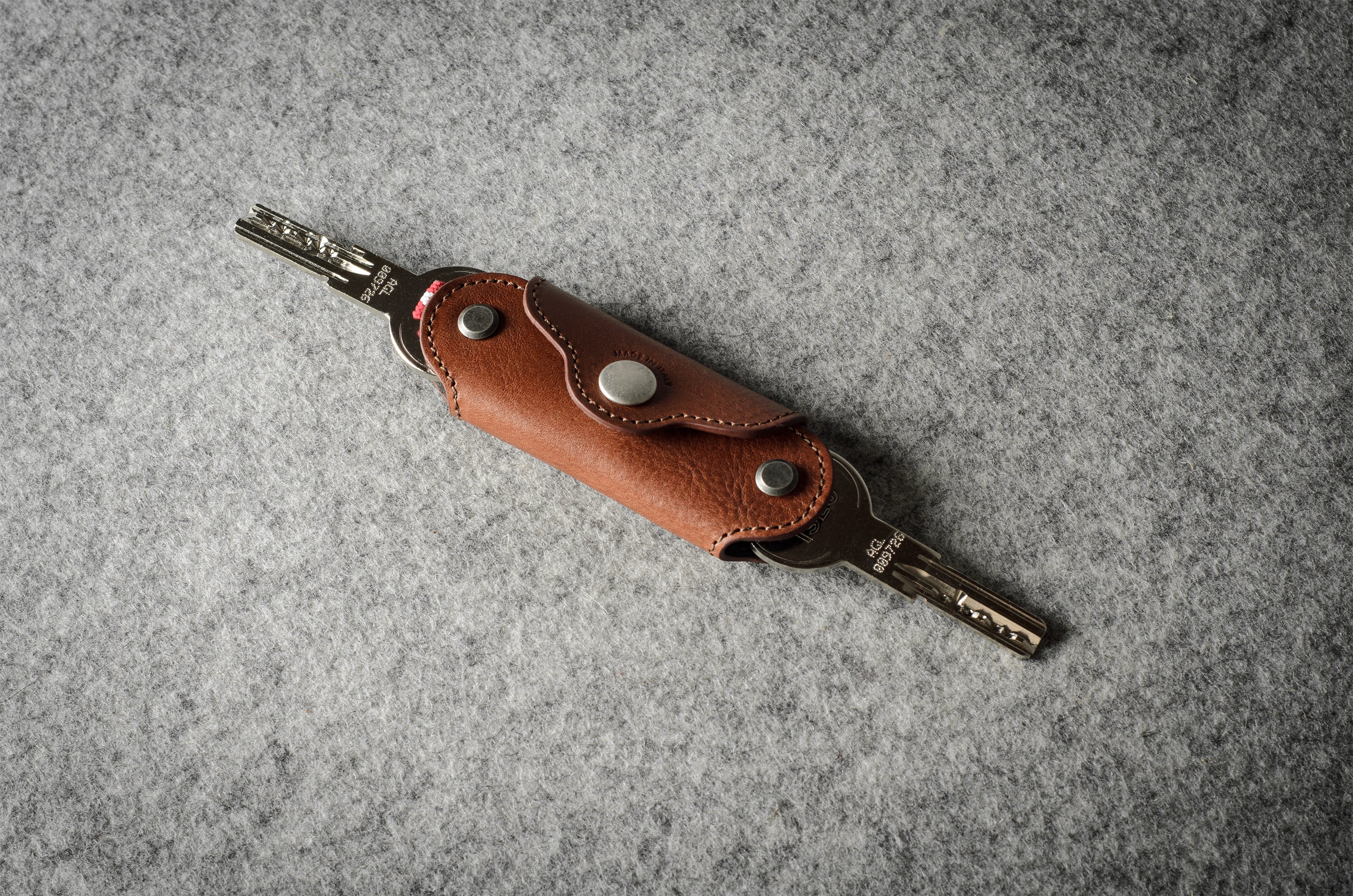 Multi-key pouch made of brown leather on a gray background