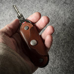 Multi-key pouch made of brown leather on a gray background