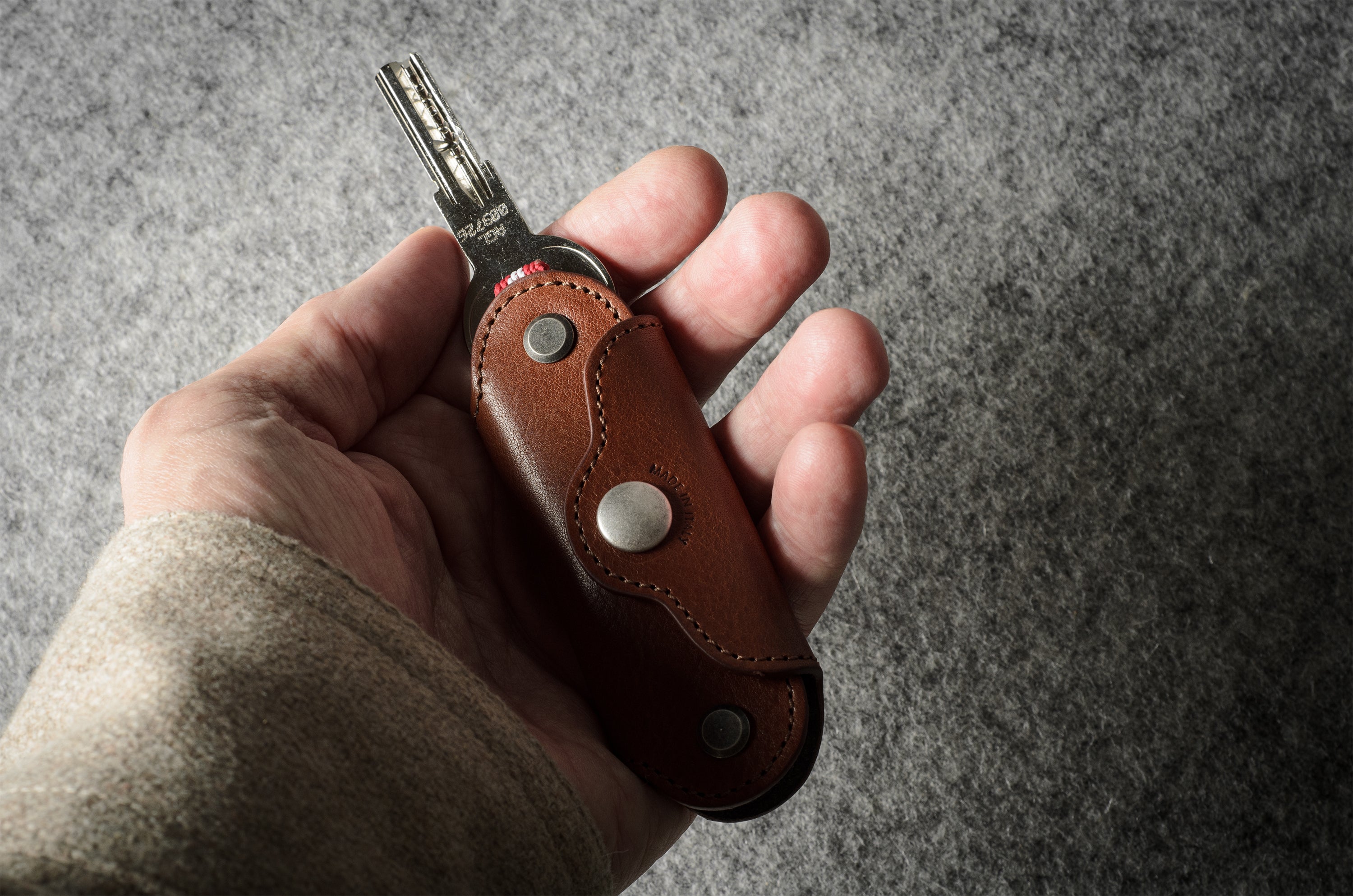 Multi-key pouch made of brown leather on a gray background