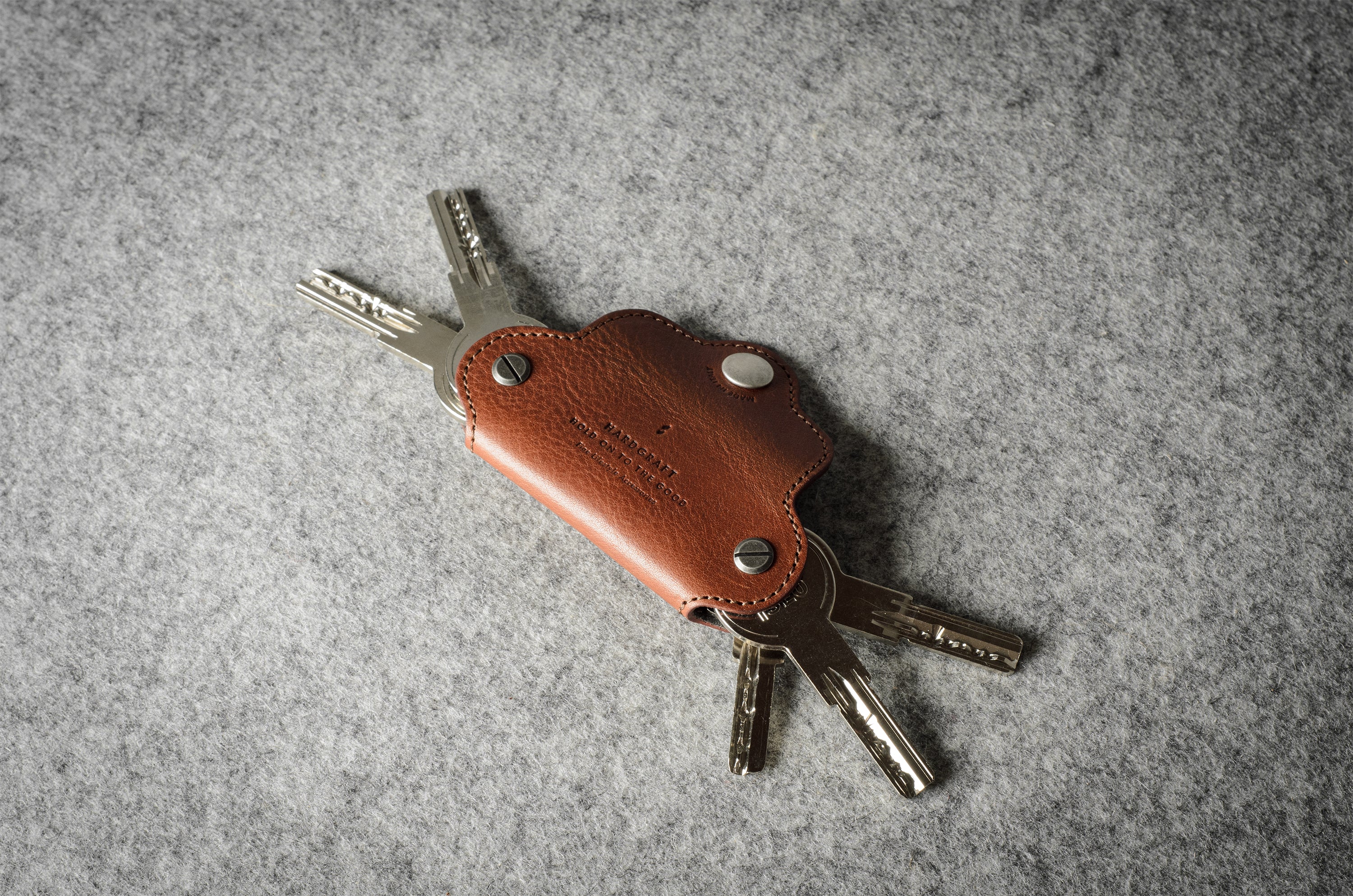 Multi-key pouch made of brown leather on a gray background