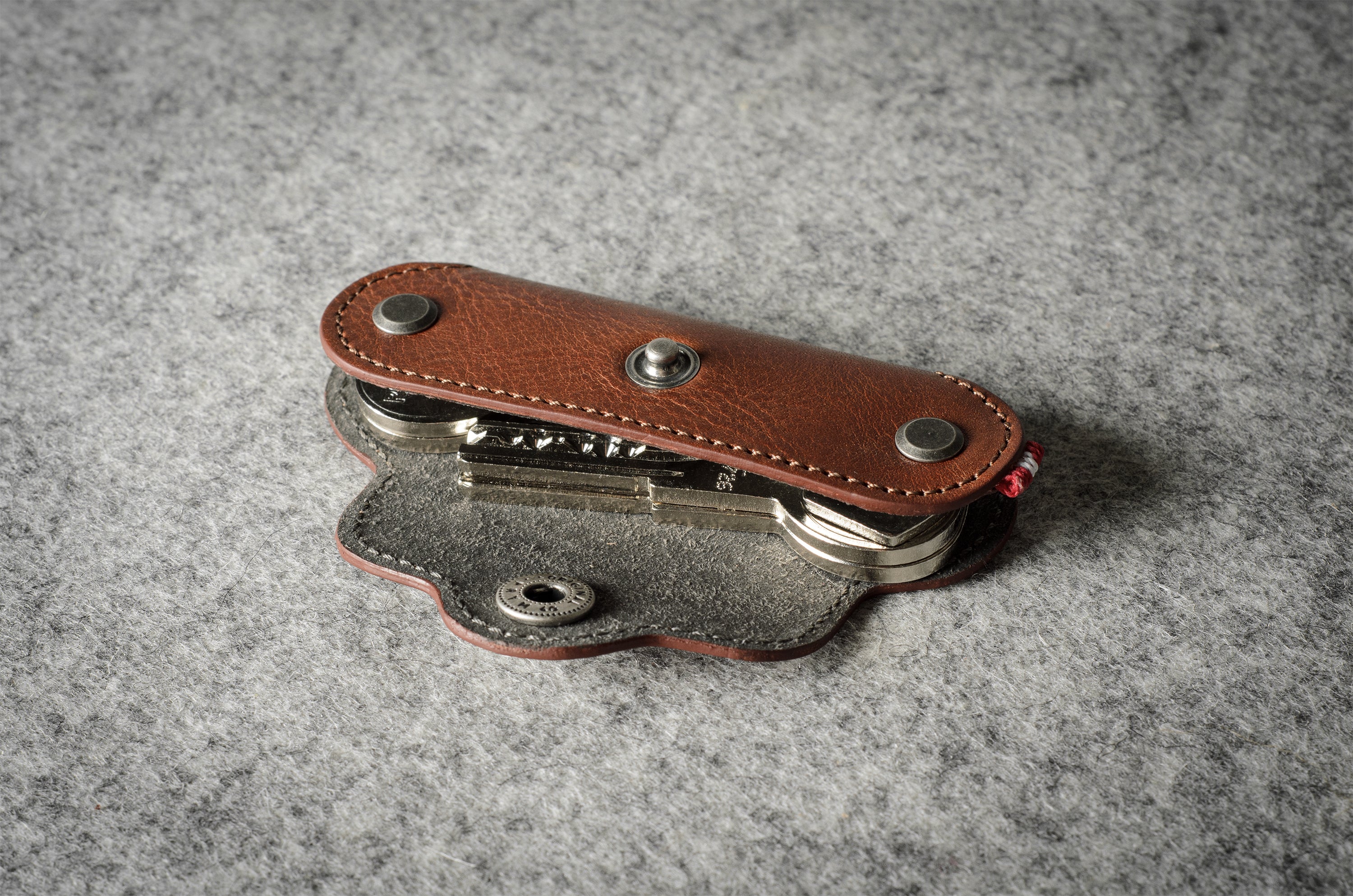 Multi-key pouch made of brown leather on a gray background