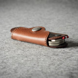 Multi-key pouch made of brown leather on a gray background