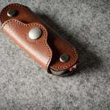 Multi-key pouch made of brown leather on a gray background