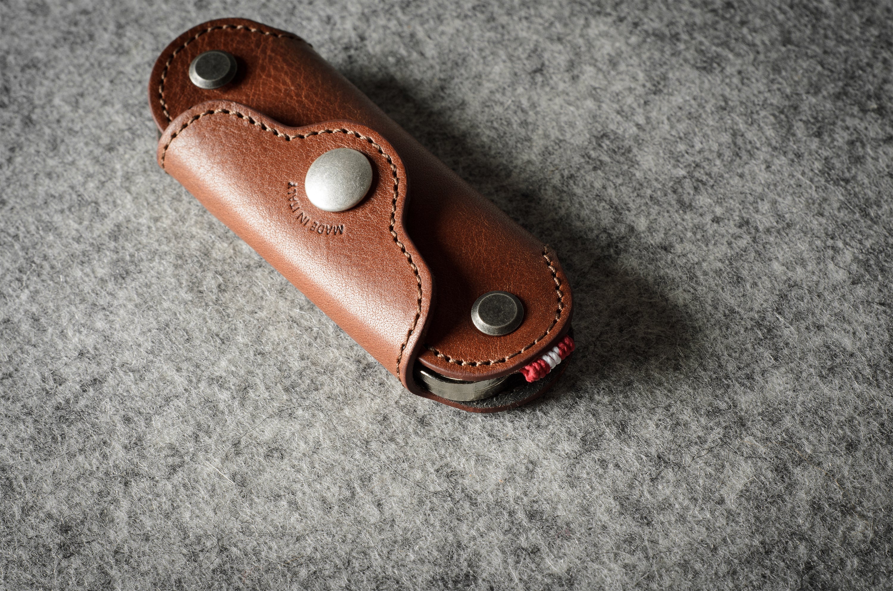 Multi-key pouch made of brown leather on a gray background